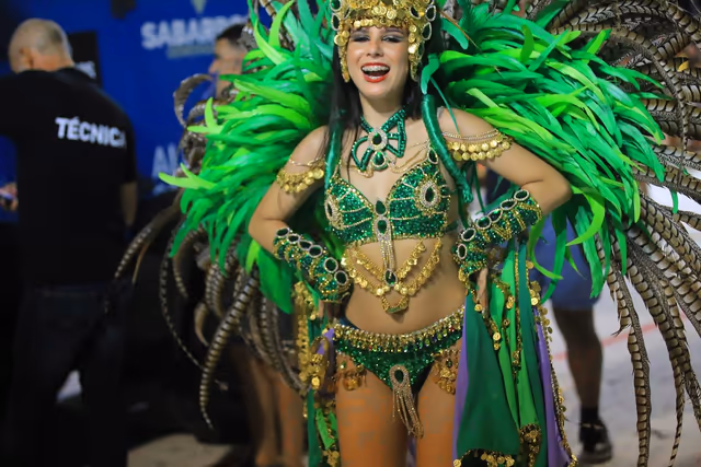 Académicos featured dancer with green feathers beside the drum section