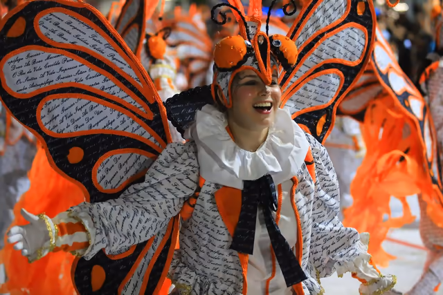 Performer in an orange butterfly costume in the Académicos parade