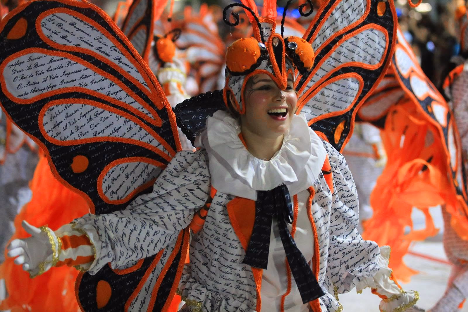 Performer in an orange butterfly costume in the Académicos parade