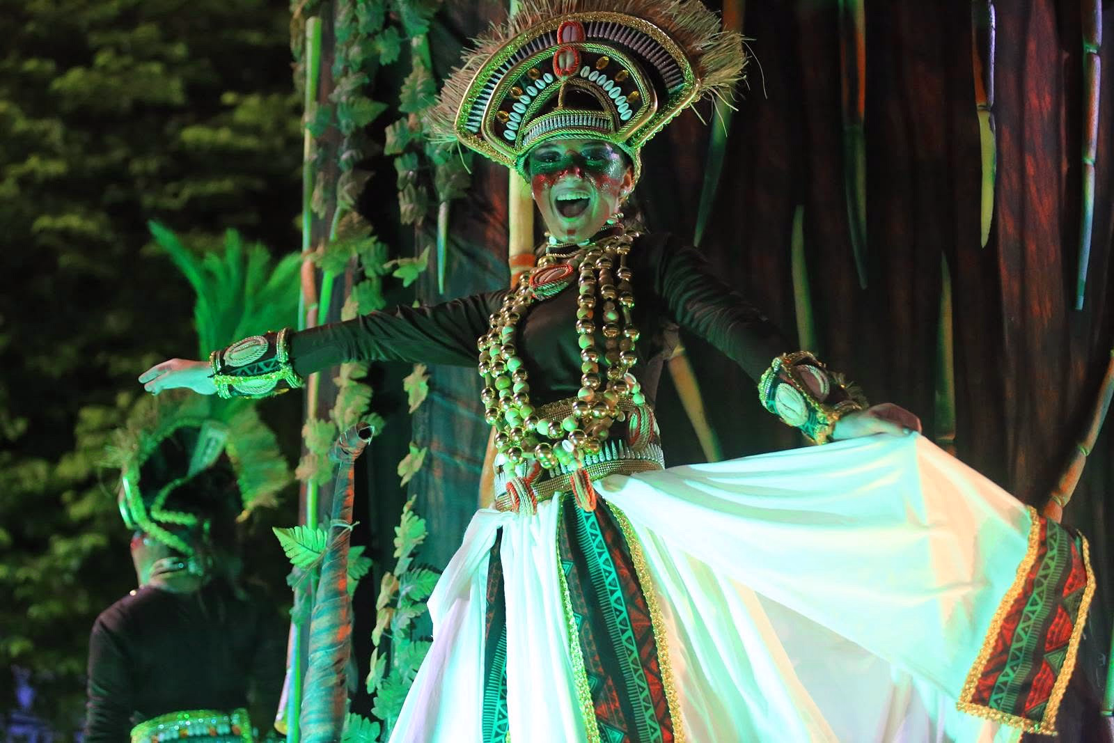 Performer in green with a white dress in the Barrio Rampla parade