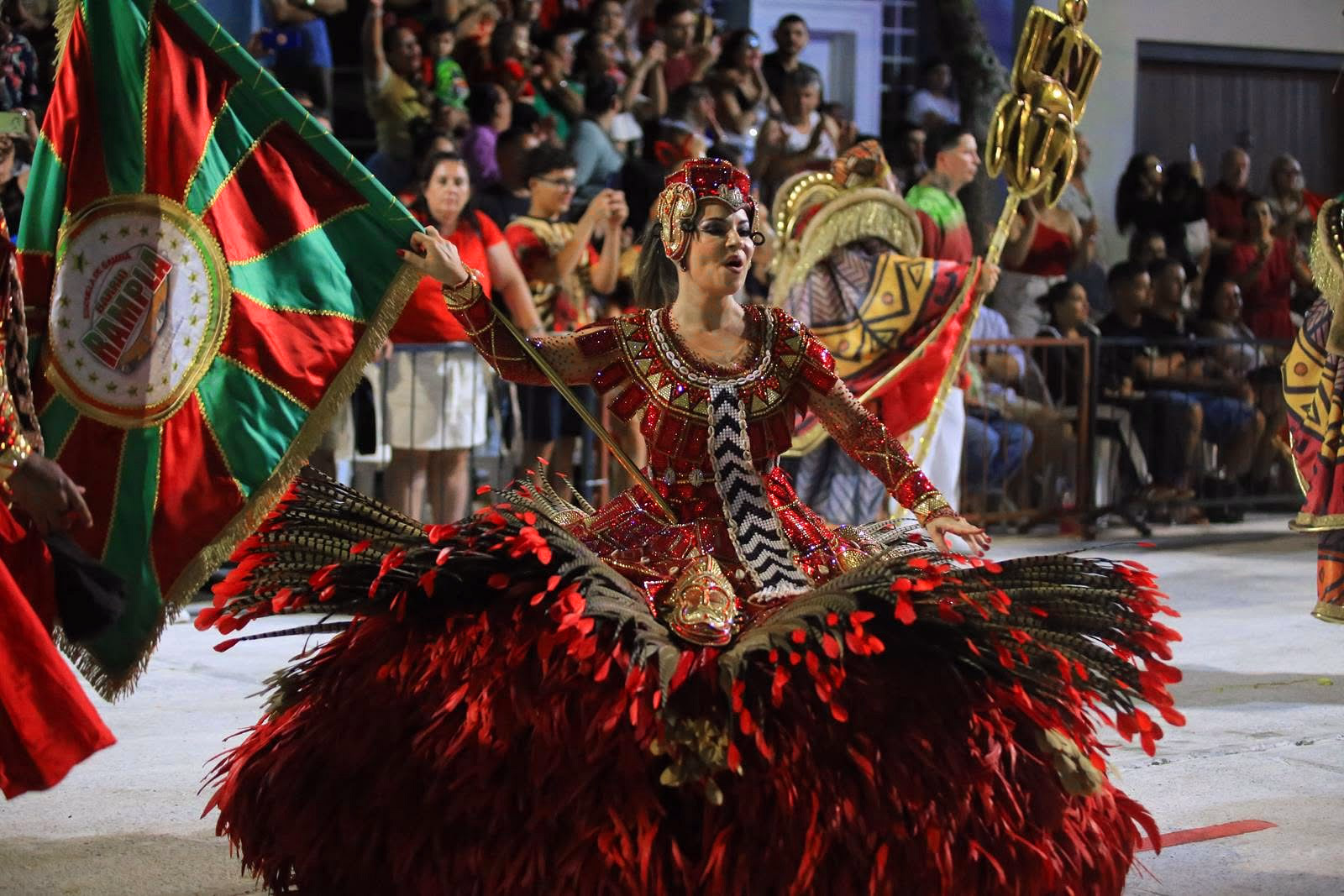 Barrio Rampla featured dancer beside the school flag