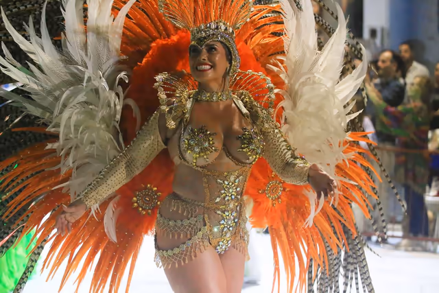 Barrio Rampla featured dancer with orange and white feathers