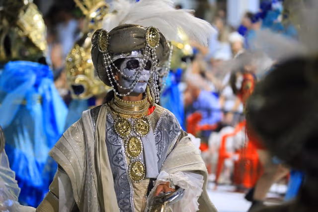 Personaje enmascarado con capa en el desfile de Emperadores