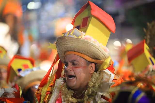 Integrante de Imperio del Ayuí con sombrero y casa de cartón